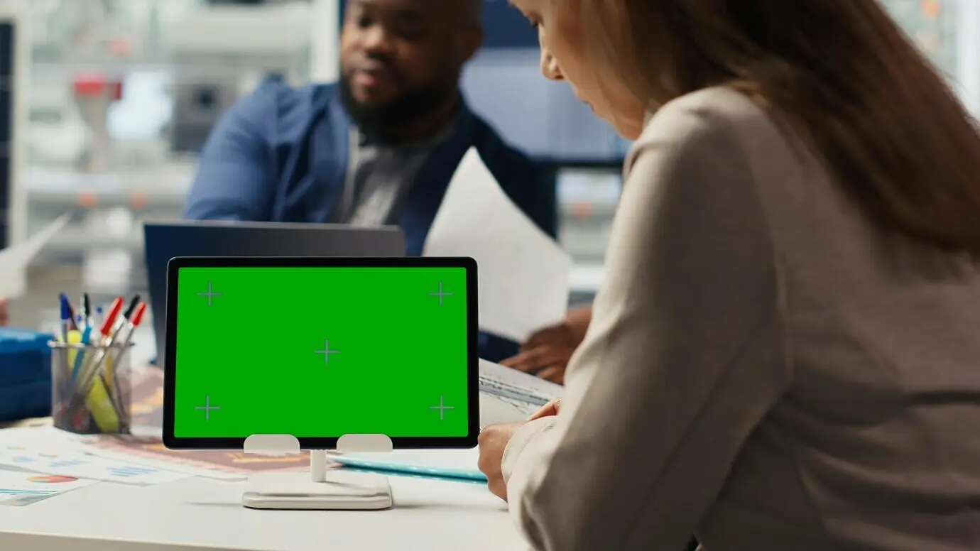 Anteilseigner in einer Photovoltaikanlage analysieren Markttrends auf einem Mockup-Tablet.