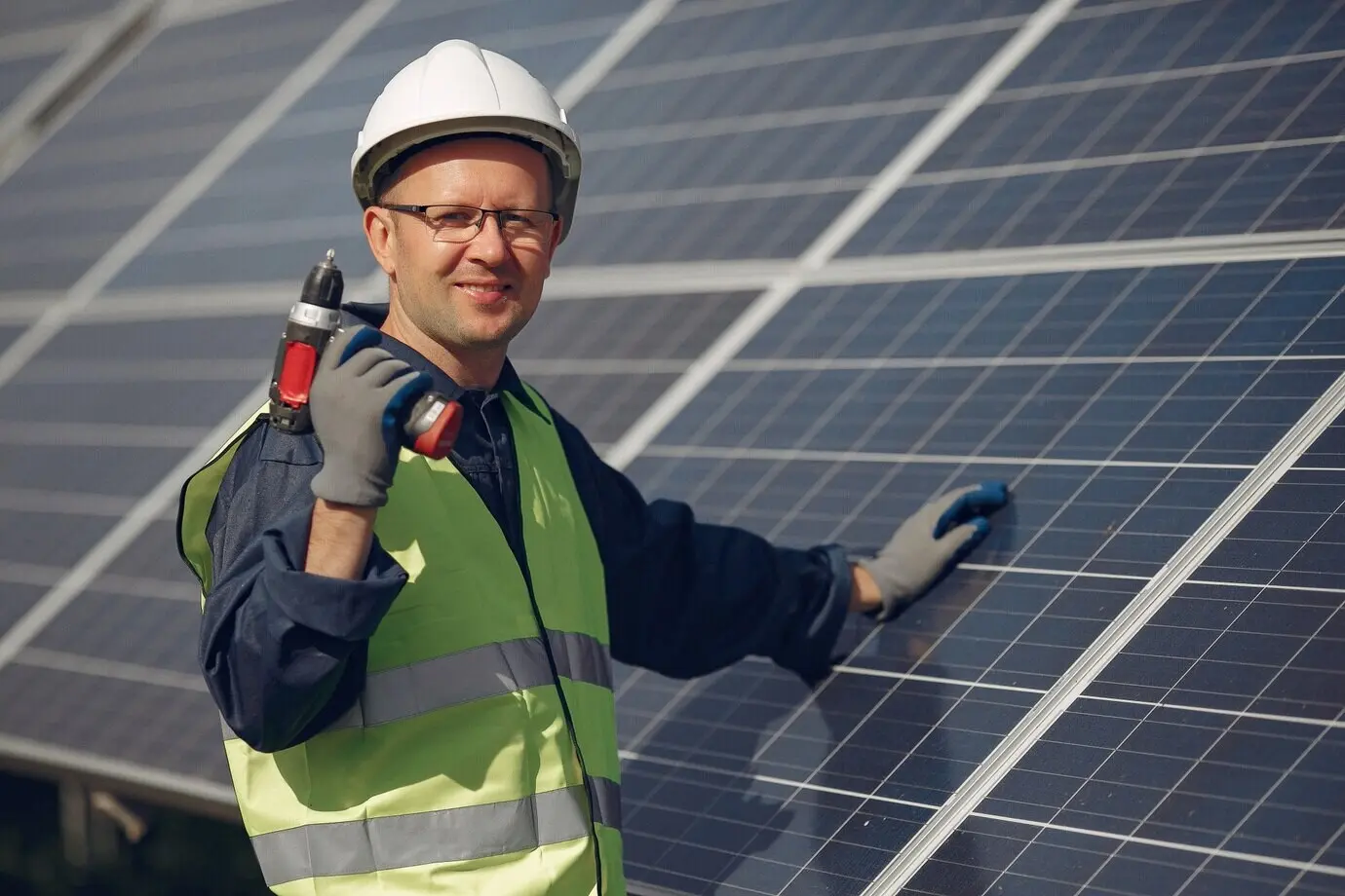 Mann mit weißem Helm in der Nähe eines Solarpanels