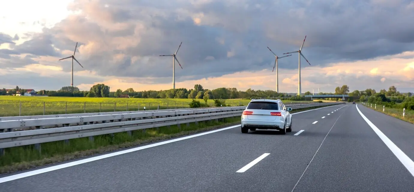 Auto auf der Autobahn, Windturbinen, erneuerbare Energie